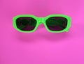 Modern green sunglasses isolate on a pink background.Traveler and summer accessories