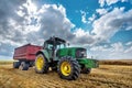 Modern green tractor on the agricultural field.