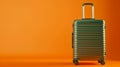 Modern Green Travel Suitcase on Orange Background, Simple and Elegant Style, Conceptual Travel and Tourism