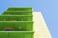 Modern green and yellow building with balconies on blue sky background. Royalty Free Stock Photo