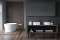 Modern grey bathroom with oval white bathtub and dark wood details Royalty Free Stock Photo