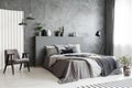 Modern grey bedroom interior with big bed with pillows and linen Royalty Free Stock Photo