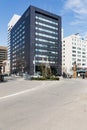 Modern grey building has rectangle and square windows form with clear blue sky and Leafless trees in the foreground in Sapporo.