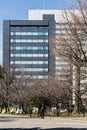 Modern grey building has rectangle and square windows form with clear blue sky and Leafless trees in the foreground in Sapporo.