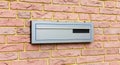 Modern grey electrical consumer unit mounted outdoors on textured brick wall facade close-up view Royalty Free Stock Photo