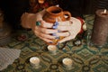 Modern gypsy witch makes love potion. Psychic hold brown pot of drink with magicak herbs