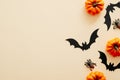 Modern Halloween background with pumpkins, spiders, paper bats with copy space for text. isolated on pastel beige background. Flat