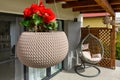 Modern hanging rattan chair with gray pillows on the garden terrace Royalty Free Stock Photo