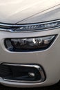 Modern headlights with a complex design and construction. Close-up of the front of the car Royalty Free Stock Photo