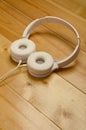 White headphones on wooden table. Modern headphone with cable