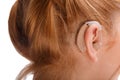 A hearing aid on the ear of a girl with red hair. Isolated . Royalty Free Stock Photo