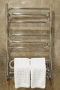 Modern heated towel rail on tiled bathroom wall