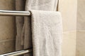 Modern heated towel rail on tiled bathroom wall