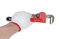 Pipe wrench in hand in protective glove on white background