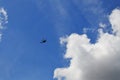 Modern helicopter flying in blue cloudy sky, low angle view Royalty Free Stock Photo