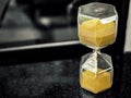 Modern hexagon hourglass with golden sand seed