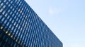 Modern high-rise building against the blue sky. Bottom view of a skyscraper in the business district. Low angle view of the glass Royalty Free Stock Photo