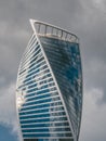 Modern high-rise building made of glass and concrete with small silhouettes of high-rise workers on the wall