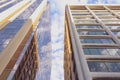 Modern high rise buildings with golden shine and blue sky reflection