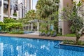 Modern high-rise residential apartment with a beautiful tropical garden and swimming pool Royalty Free Stock Photo