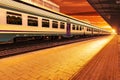 Modern high speed commuter train at the railway station at colorful sunset with vintage toning Royalty Free Stock Photo