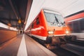 Modern high speed red passenger train moving through railway sta Royalty Free Stock Photo