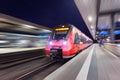 Modern high speed red passenger train moving through railway sta Royalty Free Stock Photo