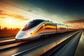 A modern high-speed train moves along the railway tracks in the evening against the backdrop of sunset. High-speed passenger rail Royalty Free Stock Photo