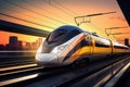 A modern high-speed train moves along the railway tracks in the evening against the backdrop of sunset. High-speed passenger rail Royalty Free Stock Photo