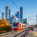 Modern high-speed train moves on the business center background. Royalty Free Stock Photo