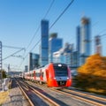 Modern high-speed train moves on the business center background. Royalty Free Stock Photo