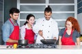 Modern hipster chef teaching people in kitchen