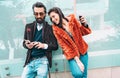 Modern hipster couple having fun using mobile smart phone outside - Social interaction concept with friends sharing photos