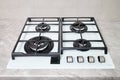 Modern hob gas stove made of tempered white glass using natural gas or propane for cooking products on light countertop Royalty Free Stock Photo