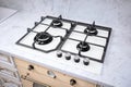 Modern hob gas stove made of tempered white glass using natural gas or propane for cooking products on light countertop in kitchen Royalty Free Stock Photo