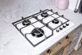 Modern hob gas stove made of tempered white glass using natural gas or propane for cooking products on light countertop in kitchen Royalty Free Stock Photo