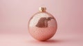 Modern holiday bauble with a shimmering gold snake skin texture, contrasted against a minimalist blush pink background