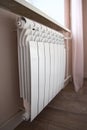 Modern home heating radiator under the window. Bimetal, aluminium radiator Royalty Free Stock Photo