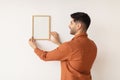 Young man hanging picture frame on the wall Royalty Free Stock Photo