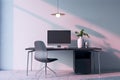 Modern home office interior with computer, furniture and other items. Concrete wall with shadows in the background. Royalty Free Stock Photo