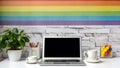 A modern home office setup with laptop on desk and a rainbow painting on wall, for pride day. Generative AI Royalty Free Stock Photo