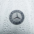 The modern hood emblem of Mercedes-Benz car in raindrops. Royalty Free Stock Photo