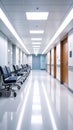Modern hospital corridor with waiting chairs and doors under bright overhead lights Royalty Free Stock Photo