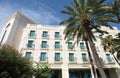 Modern hotel building with blue windows and palm trees Royalty Free Stock Photo