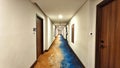 a modern hotel hallway featuring distinctive carpet and simple wall decor. horizontal or landscape orientation Royalty Free Stock Photo