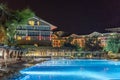 Modern hotel or house with a dark blue water swimming pool at night. Stuff clean pool at night. Royalty Free Stock Photo
