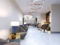 A modern hotel with a reception area and lounge with large upholstered designer chairs and a large chandelier of golden rings Royalty Free Stock Photo
