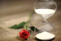 Modern hourglass and red rose with copy space. Royalty Free Stock Photo