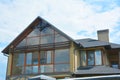 Modern house attic construction with roof guttering and panoramic mansard, attic skylight window. Royalty Free Stock Photo