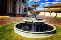 Modern House with blue sky and green grass with a water fountain